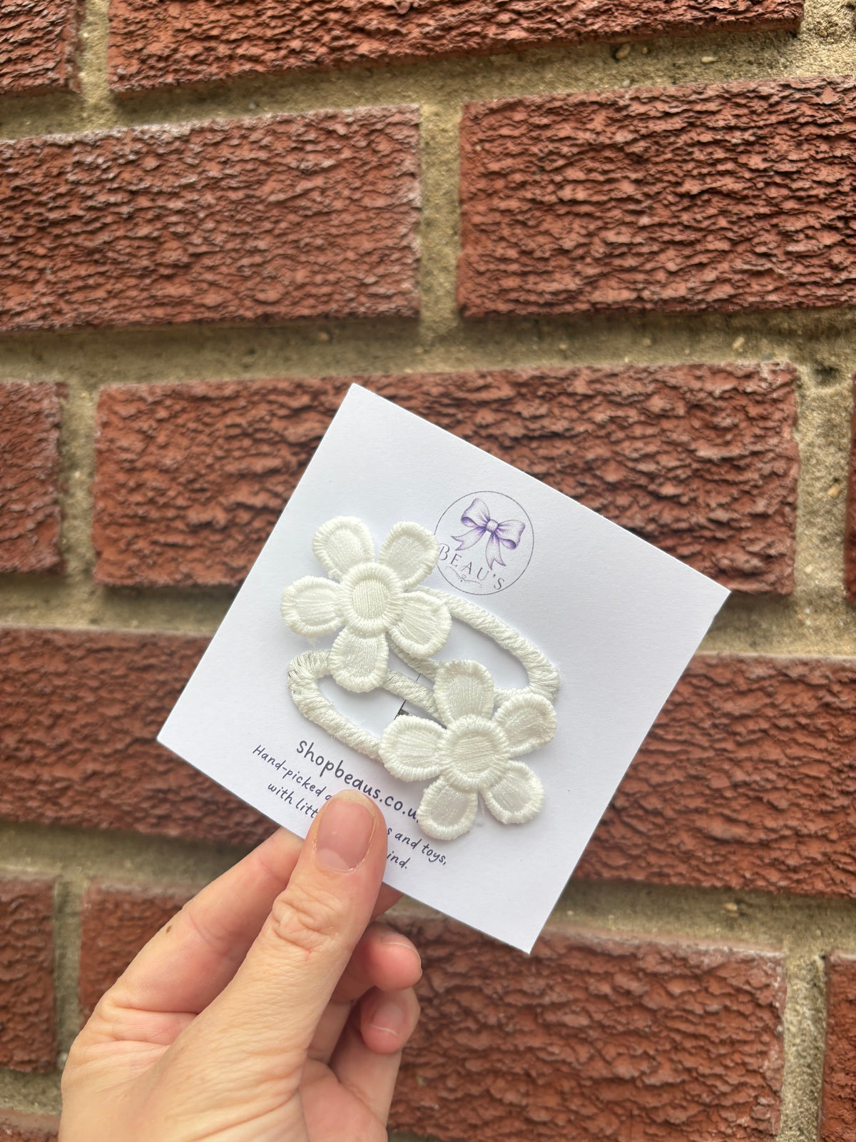Embroidered flower snap clips pair.
