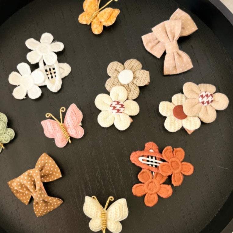 Embroidered flower snap clips pair.
